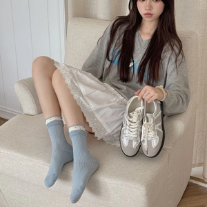 Cute light blue ribbed crew socks with white polka dot frill cuffs and casual silver sneakers