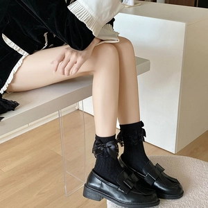 Detailansicht der schwarzen Lolita-Spitzensocken mit Satinschleifen und Plateauschuhen