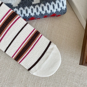 Detail of vintage striped knit socks featuring vibrant color blocking and neat stitching