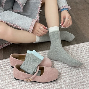 Detail of grey ribbed crew socks with contrast trim worn with pink Mary Jane shoes
