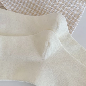 Detailed macro view of cream ribbed knit socks with soft texture for autumn and winter