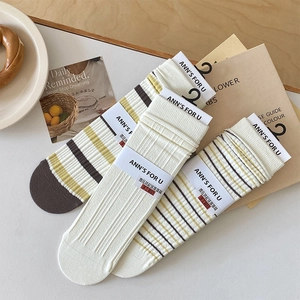 Detailed view of three pairs of ribbed cotton socks featuring fine stripe accents