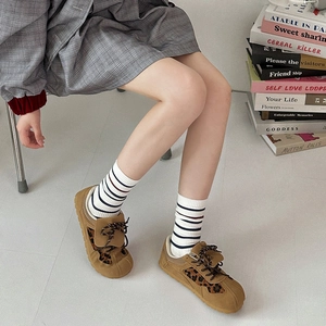 Gros plan de chaussettes mi-hautes à rayures rétro avec baskets léopard marron décontractées