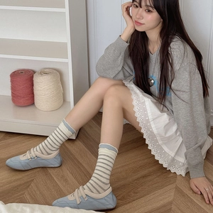 Japanese style striped crew socks with ruffled edges worn with light blue casual shoes