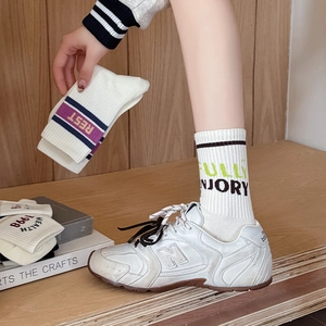 Detailed view of white cotton ribbed crew socks with purple stripes and vintage embroidery
