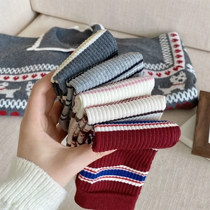 Close-up of assorted ribbed knit socks in grey and burgundy with striped cuff details