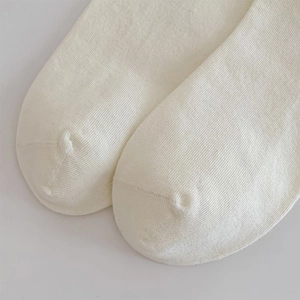Close-up of white knit socks with fine ribbing and seamless toe stitching detail