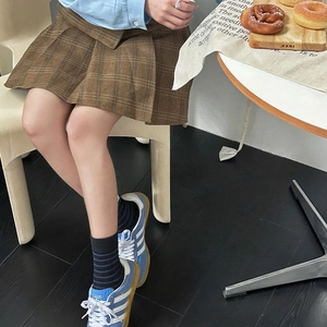 Detailed view of the pleated brown plaid mini skirt with classic school style design