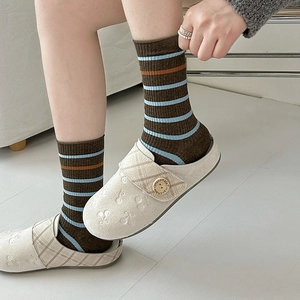 Détail de chaussettes à rayures vintage marron et bleu avec sabots aux cerises