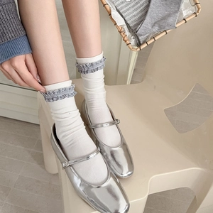 Détail de chaussures Mary Jane argentées avec chaussettes à volants et broderie