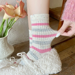 Detail of knit ribbon socks featuring colorful speckled yarn and soft pastel stripes