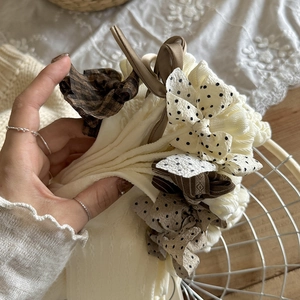Detailansicht der cremefarbenen Rüschensocken mit Vintage-Karo- und Polka-Dot-Schleifen