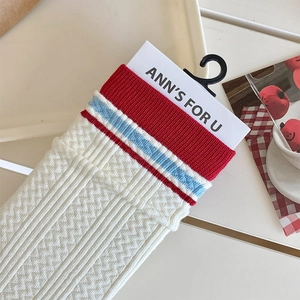 Detail of white cotton crew socks with red ribbing and blue contrast stripes
