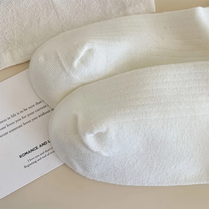 Détail de chaussettes en coton côtelé blanc avec couture fine et texture tricotée douce