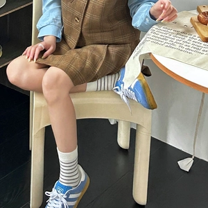 Detail of mid-calf socks with grey stripes worn with retro blue sneakers and plaid shorts