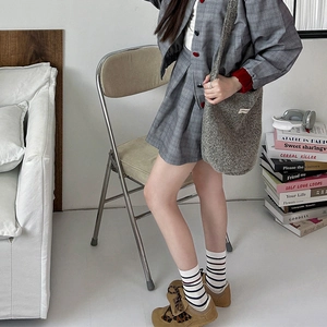 Détail de chaussettes rétro à rayures avec jupe à carreaux et baskets style collège