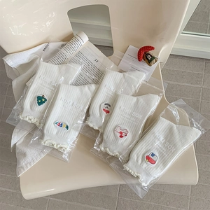 Détail de cinq paires de chaussettes blanches brodées avec bords ondulés mignons