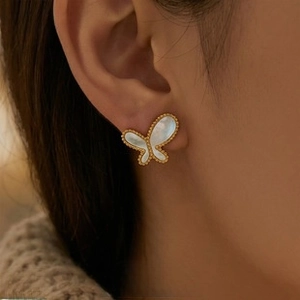 Close-up of elegant gold butterfly stud earrings with white mother of pearl inlay