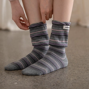 Detail of grey striped socks with a fabric label and vintage slouchy texture