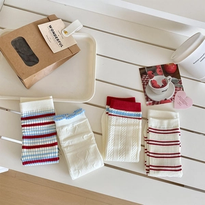 Close-up of four pairs of sweet knit socks featuring heart jacquard and blue red stripes