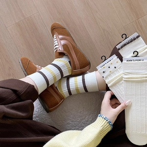 Three pairs of vintage knit crew socks in stripes, polka dots, and ribbed ivory styles