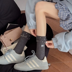Close-up of cute polka dot knit socks with delicate white bow embroidery for women