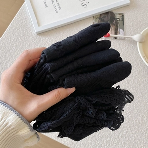 Detail von geschichteten schwarzen Lolita-Spitzensocken mit feiner Netzstruktur und Rüschen