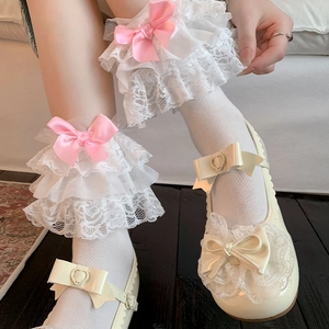 Detailed close-up of Lolita white lace socks featuring pink ribbons and layered ruffles