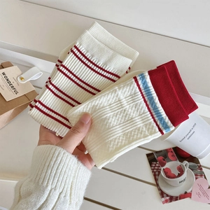 Close-up of Japanese style knitted cotton crew socks with red stripes and lace details