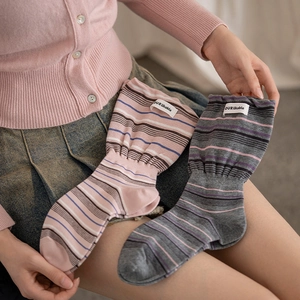 Detail of vintage striped knit socks featuring a branded woven label and cozy texture
