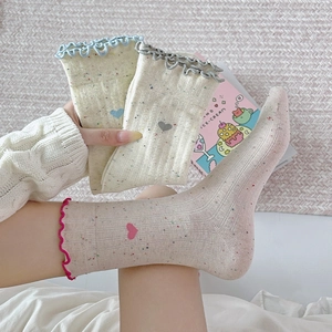 Detail of sweet heart embroidery and ruffled lettuce trim on colorful dot crew socks