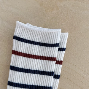 Gros plan sur la texture côtelée et les rayures des chaussettes en coton blanc et rouge bleu