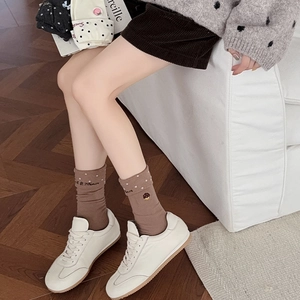 Detail of brown cotton socks featuring white polka dots and delicate cake embroidery