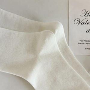 Gros plan détaillé de chaussettes en tricot ivoire avec texture côtelée et talon renforcé