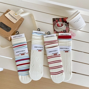 Detail view of four pairs of sweet Korean-style crew socks with heart patterns and stripes