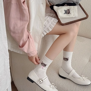 Detail of white mid-calf sock featuring cute cat embroidery and pink 3D bow accent