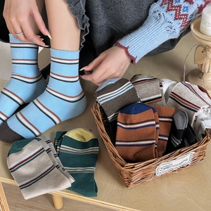 Close-up of retro striped cotton mid-calf socks in warm autumn tones and knit texture