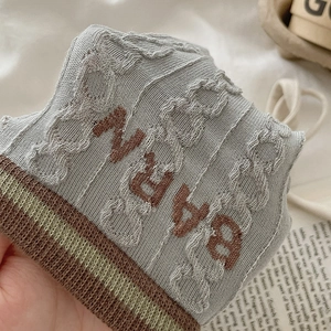 Macro detail of knit socks with vintage brown stripes and bold ARNV jacquard texture
