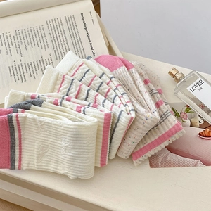 Detailed knit texture of pink and grey striped cotton crew socks with bow lace trim