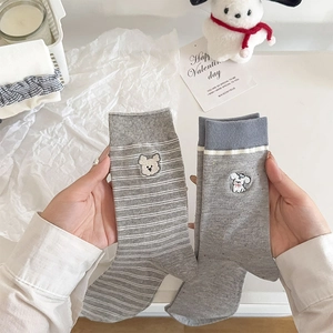 Gros plan sur des chaussettes japonaises en maille avec broderie chiot et motifs rayés