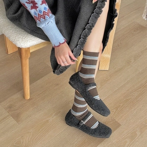 Detail of grey woolen Mary Jane flat shoes paired with vintage striped crew socks