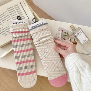 Close-up of pink and grey striped cotton socks with bow lace trim and vintage props
