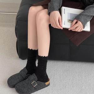 Retro grey clogs with adjustable buckle and colorful speckled ruffle socks on model