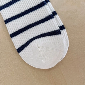 Détail de chaussettes en coton à rayures bleues et blanches avec maille côtelée fine