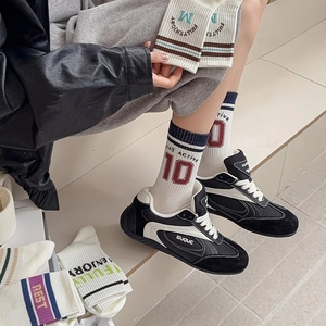 Detail of college style striped crew socks with athletic lettering and high waist design