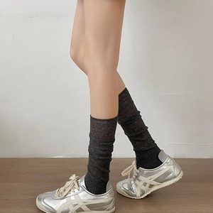 Macro view of sheer dark grey slouch socks paired with silver sneakers for a balletcore style