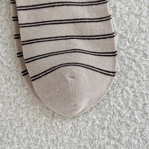 Macro shot of striped knit socks showing fine cotton texture and precise toe stitching