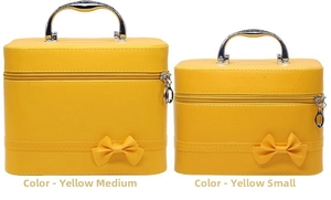Detail of yellow PU leather makeup cases with metal handles and decorative bows