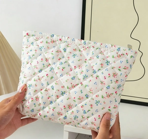 Detailed close-up of a quilted floral makeup bag with a soft texture and zipper