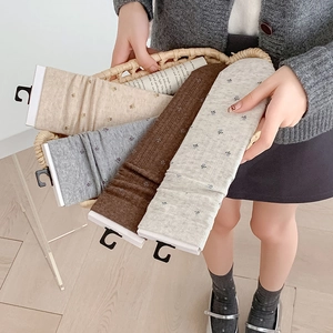 Detailed view of four pairs of floral embroidered cotton crew socks in neutral tones